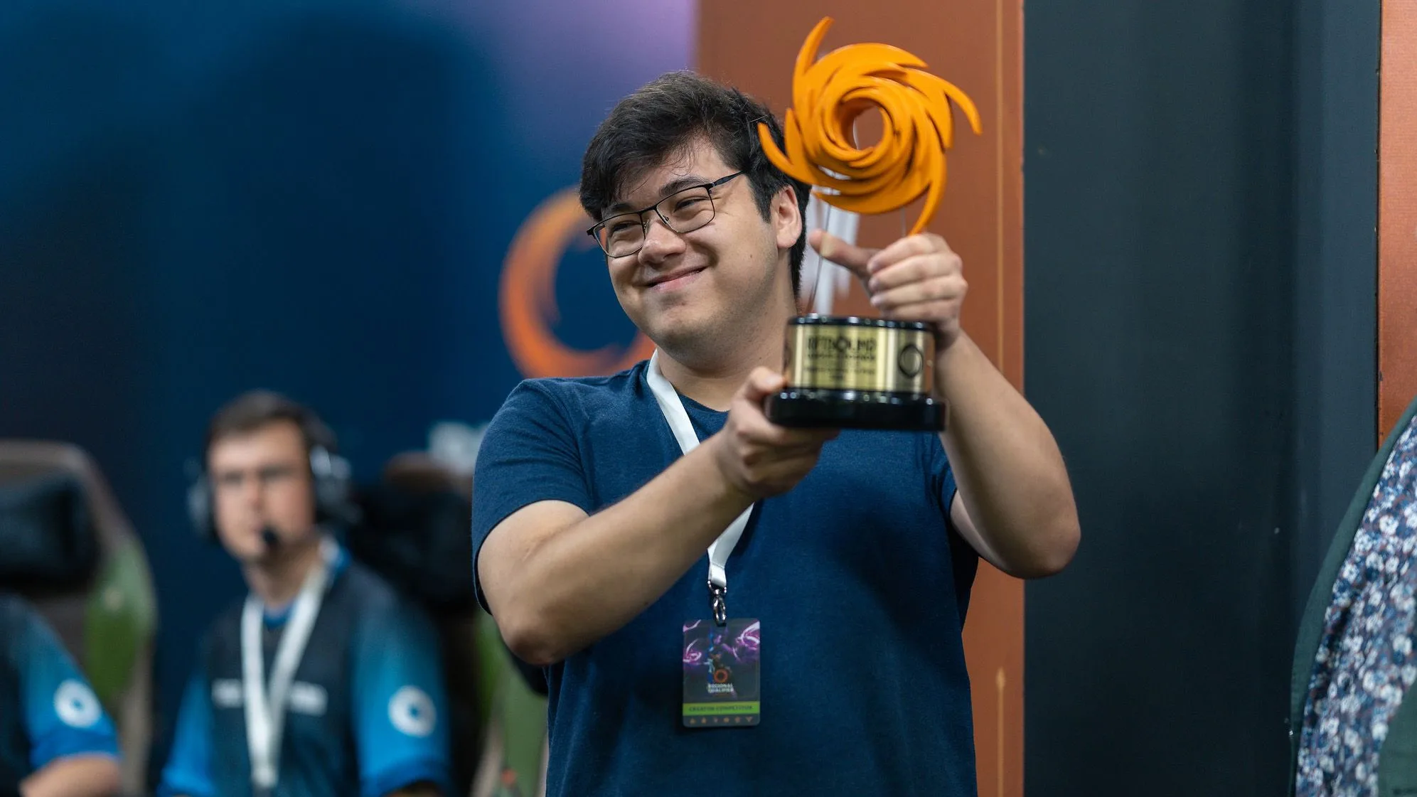 Riftbound championship trophy Riftbound tournament competitor holding an orange championship trophy during an official competitive event.