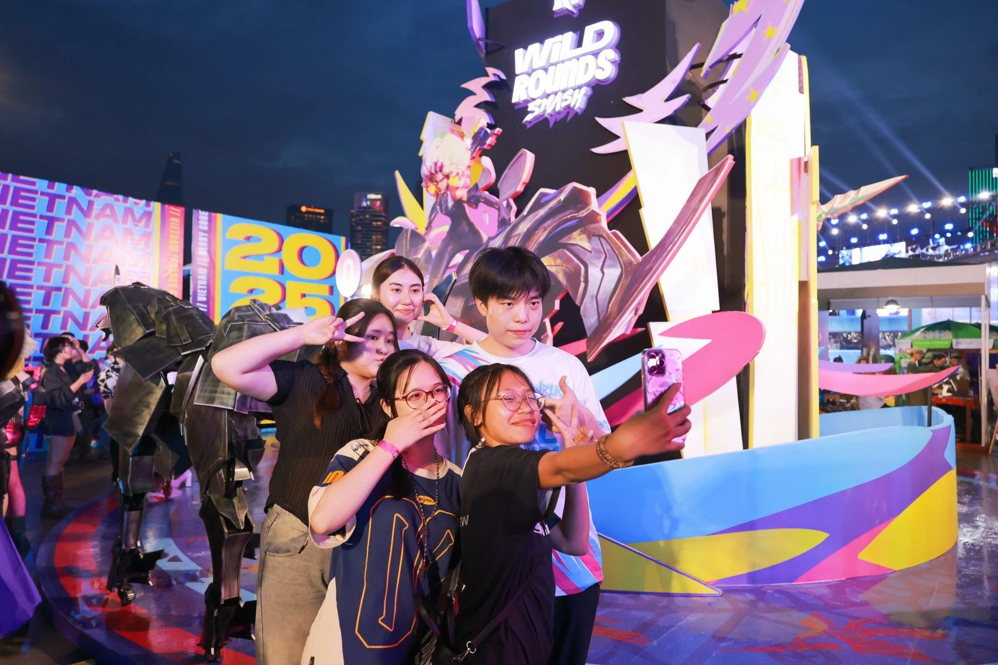 Wild Rounds SMASH community celebration in 2025 Wild Rift fans taking a group selfie in front of a colorful Wild Rounds SMASH display during the 2025 Vietnam edition