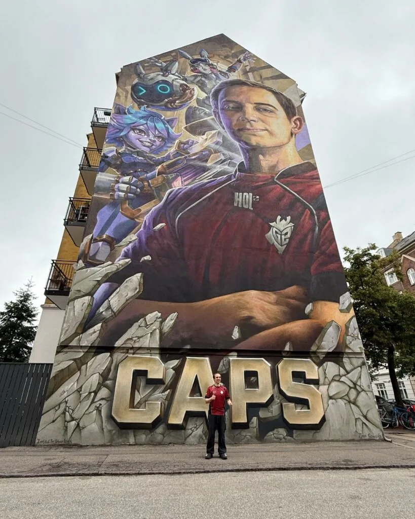 Caps Hall of Legends mural in Copenhagen and him posing in front of ti.