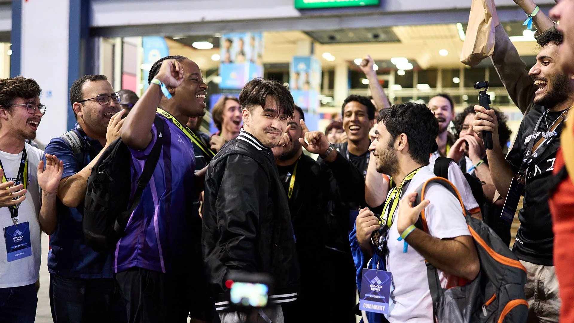 French fighting game community at a major tournament Members of the fighting game community celebrating together at a tournament venue