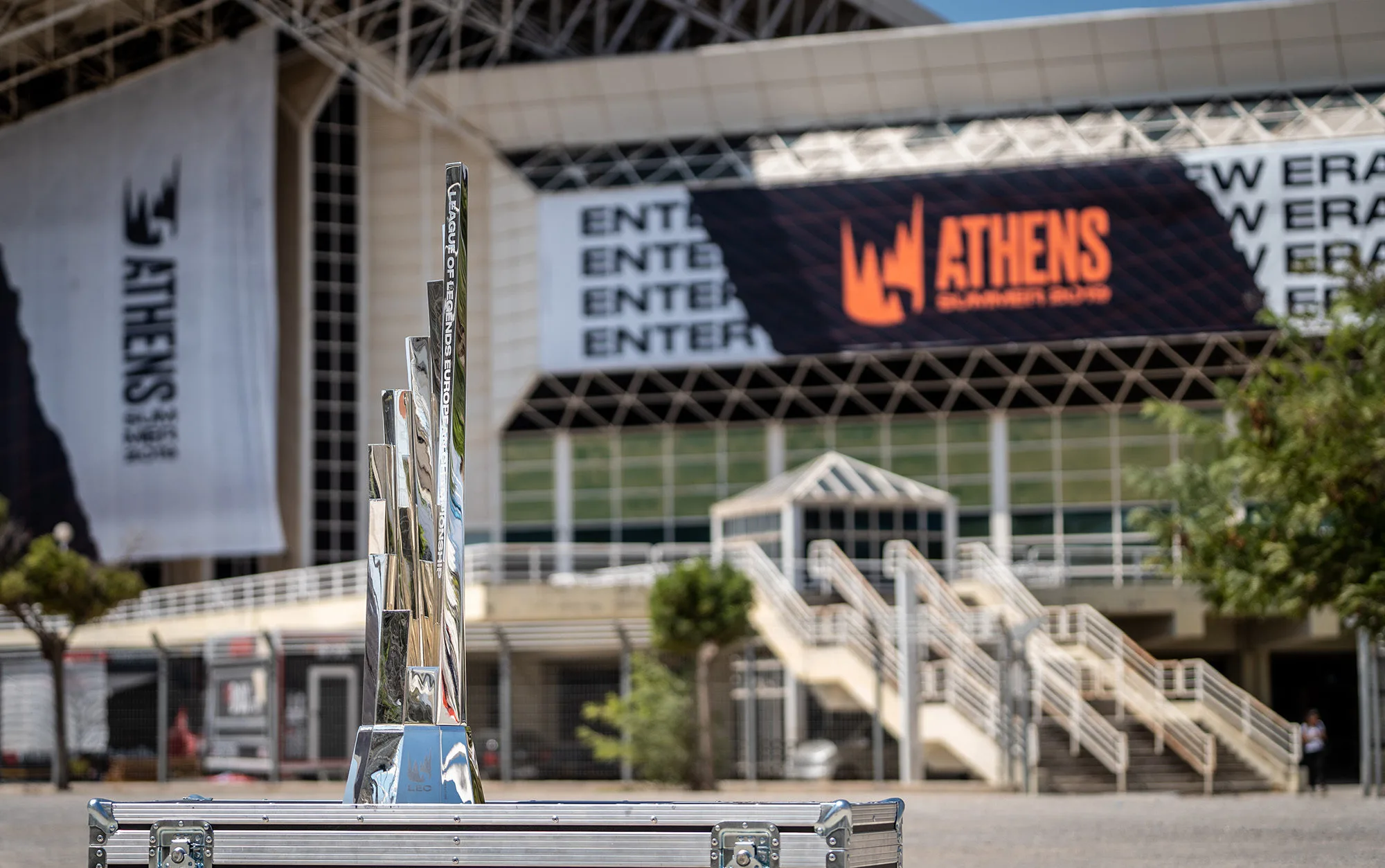 Tall silver LEC trophy displayed outside a large esports venue Tall silver LEC trophy displayed outside a large esports venue